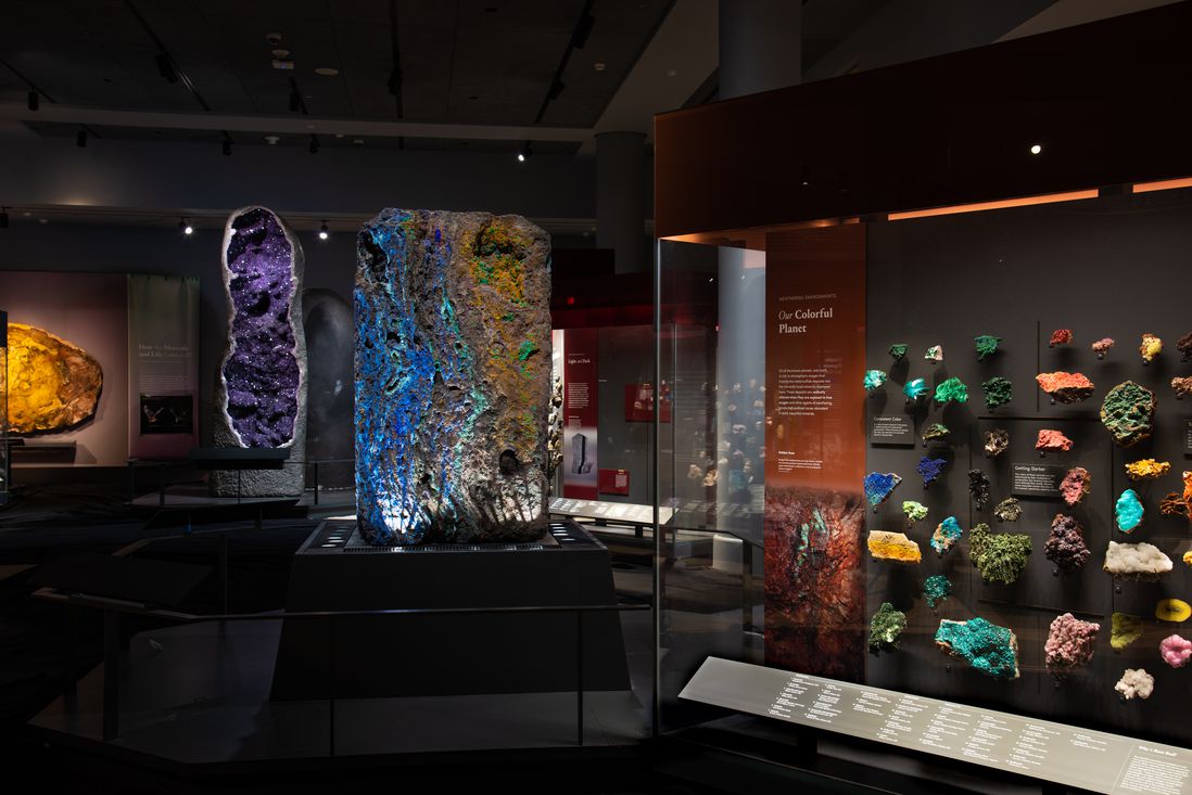 A photograph shows a glimpse of the hall with its display cases of various minerals and the big open geode